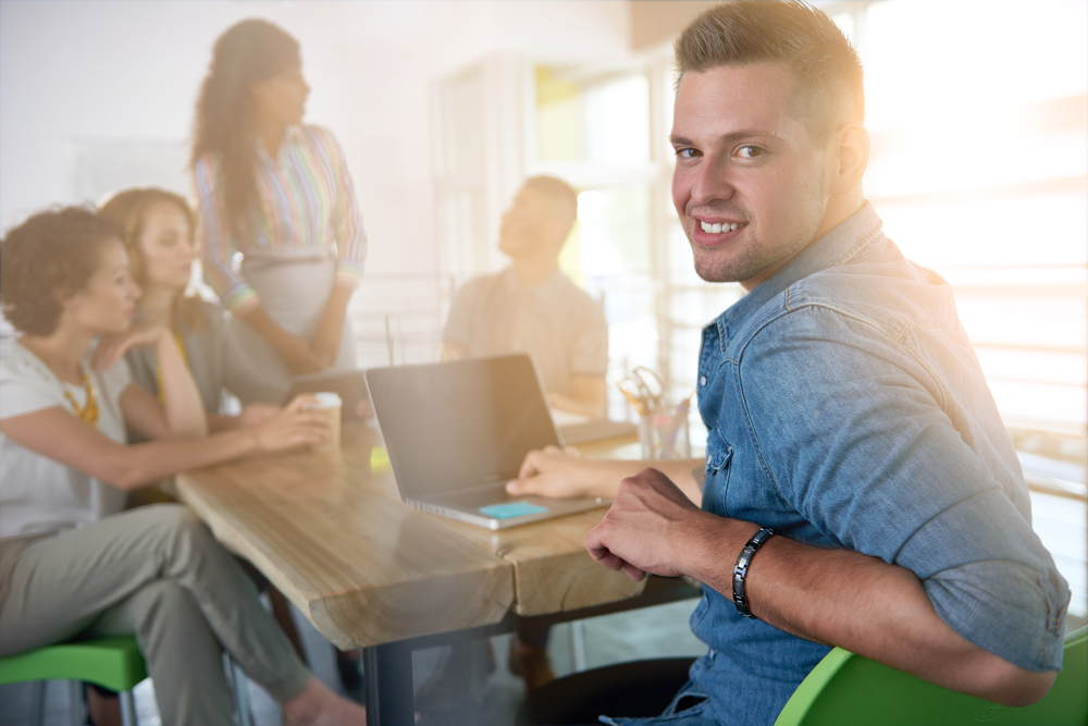Image of a succesful casual business man using laptop during meeting Image of a succesful casual business man using laptop during meeting